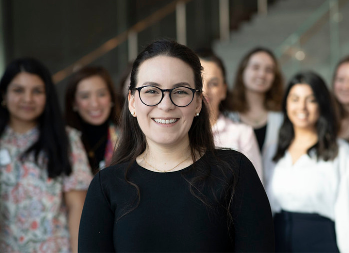 Woman with glasses smiling at the camera